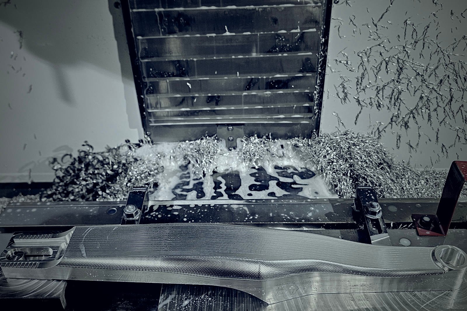 Wrzeciono frezarki CNC podczas obróbki długiego elementu aluminiowego zamocowanego na stole maszyny